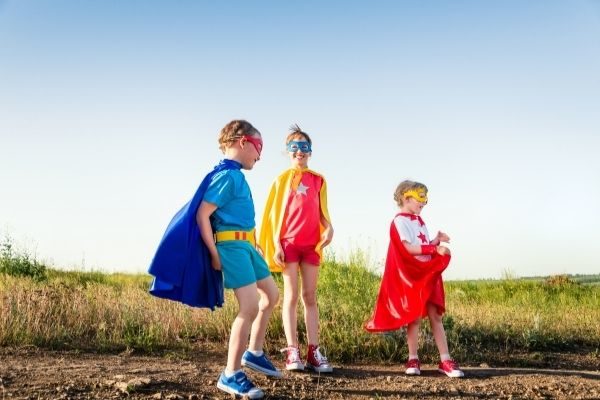 kids playing outside as superheroes