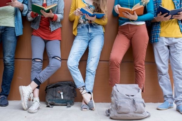 teenagers standing and reading
