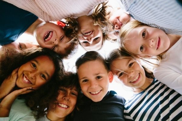 kids in a circle smiling and laughing