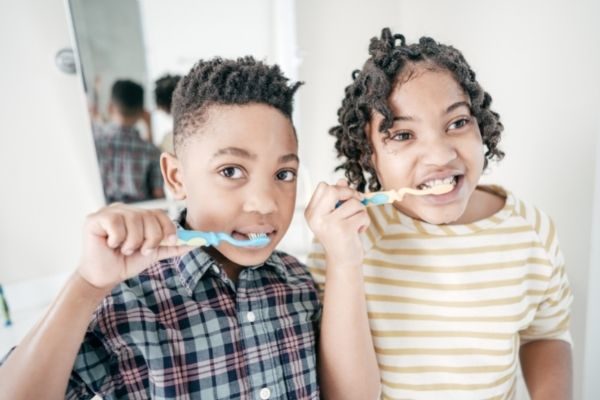 boy and girl brushing their teeth