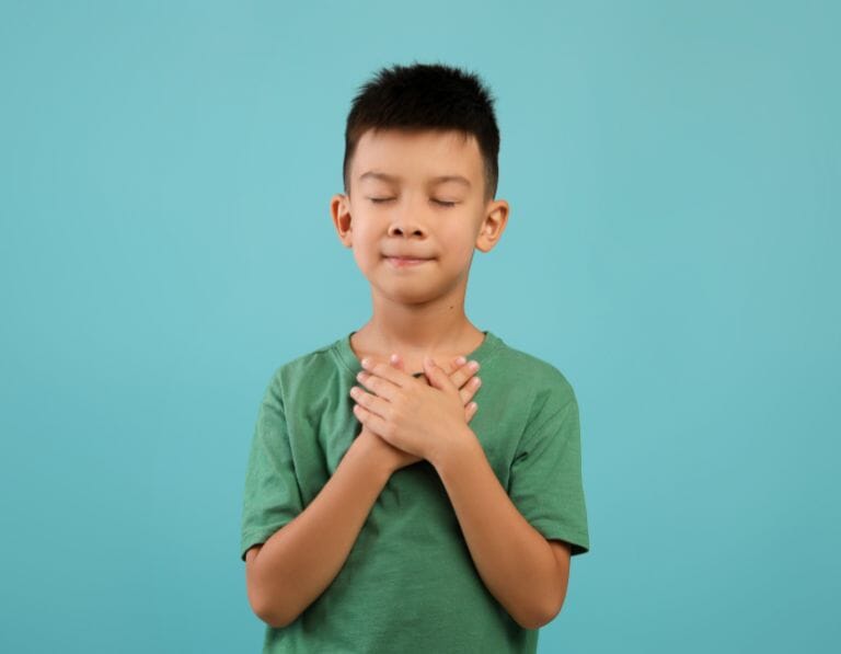boy hands on heart: best kindness quotes for kids and for school