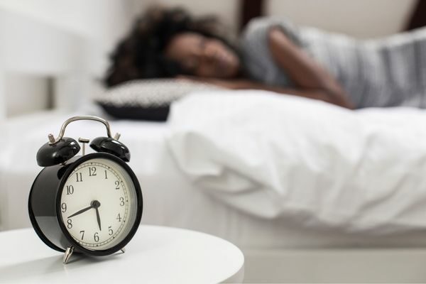 woman sleeping and alarm clock