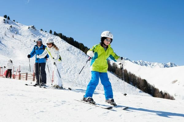 family skiing down a mountain; creative outdoor winter activities for families
