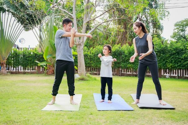 parents and child working out together outside