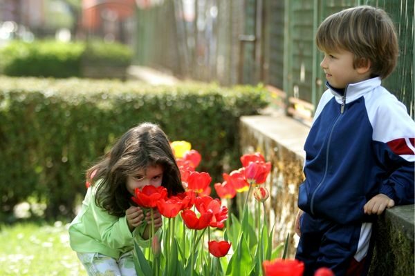 two kids smelling tulips