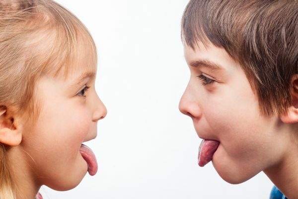 two kids sticking their tongue out at each other; tongue twisters easy for pronunciation