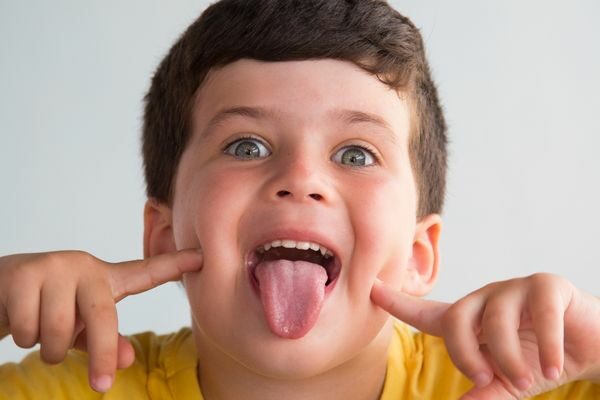 boy pointing to his tongue and sticking it out; short hard tongue twisters for children