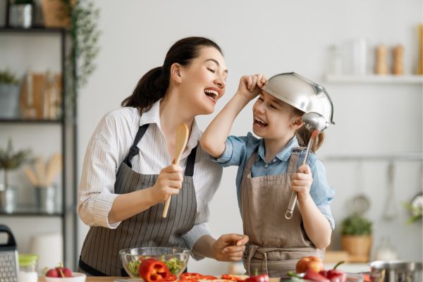 mom and child cooking in the kitchen; family staycation ideas that are kid friendly
