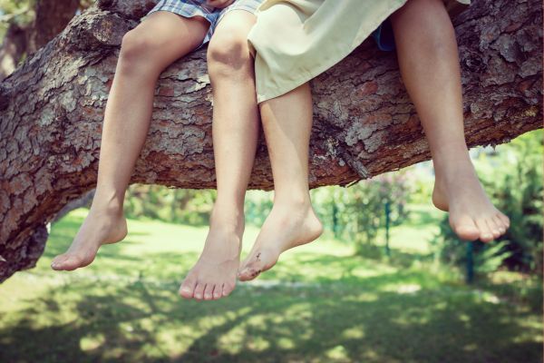 two kids sitting on tree branch with dangling feet; fun favorite things questions to ask people