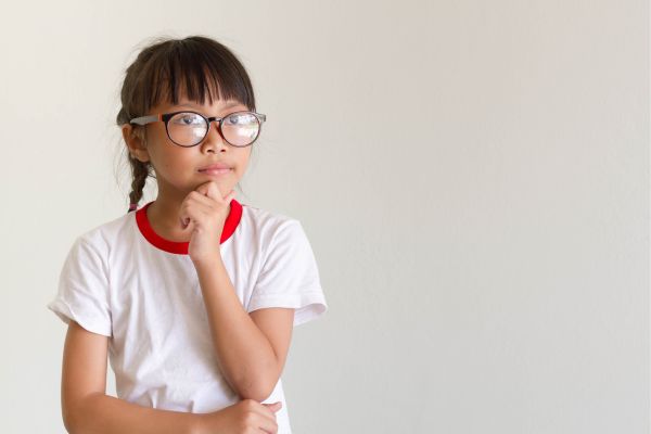 little girl in glasses thinking