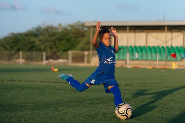 boy kicking a soccer ball