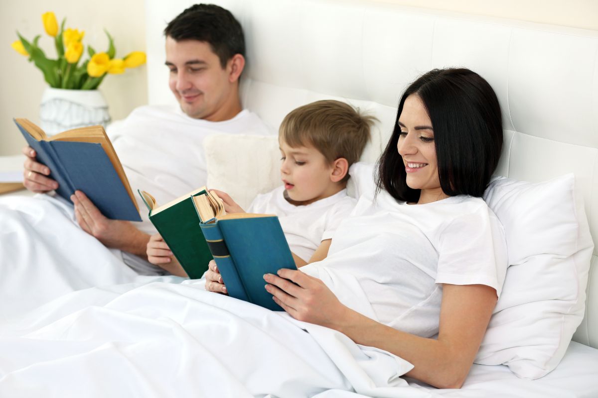 family of three reading in bed