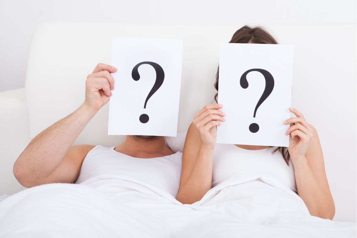 couple laying in bed holding up question mark signs; dirty Mr and Mrs questions; naughty hen party