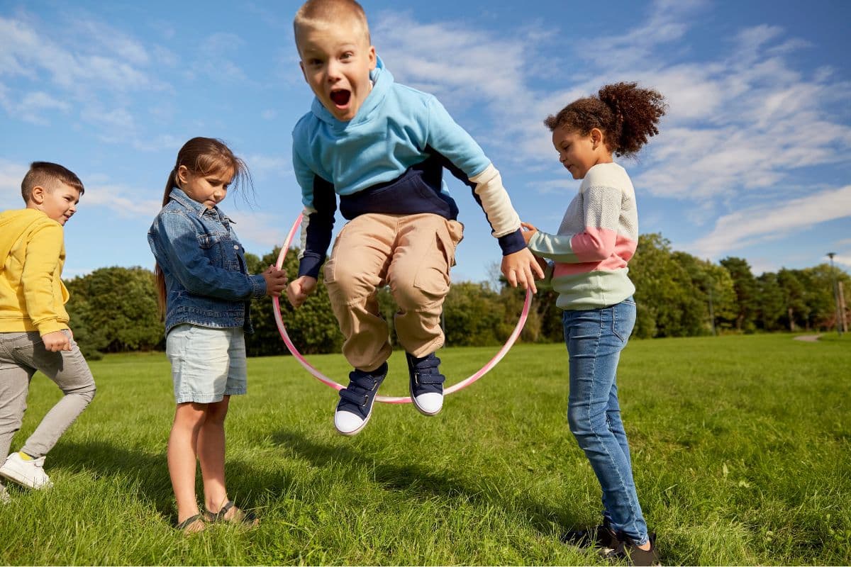 kid jumping through hula hoop; fun large group games for kids
