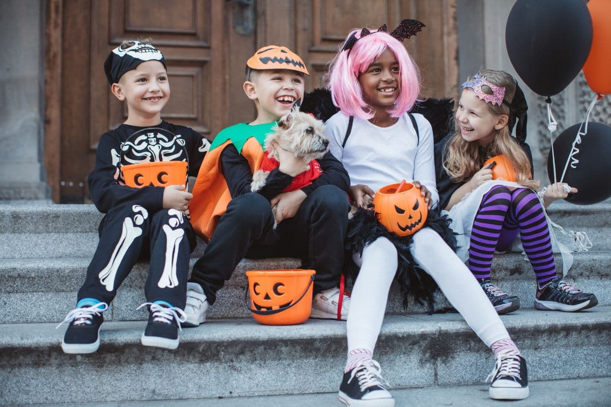 kids dressed in Halloween costumes and sitting on steps