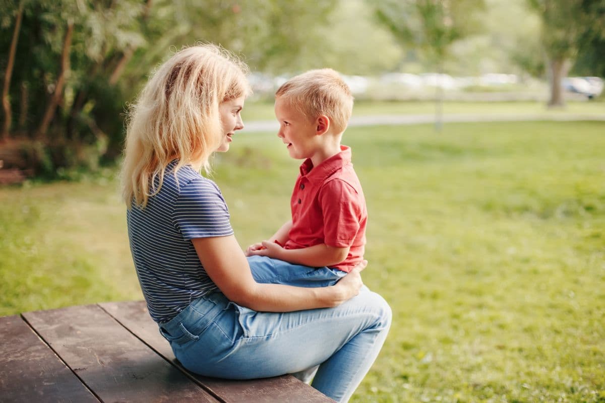 boy sitting on mom's lap looking at one another