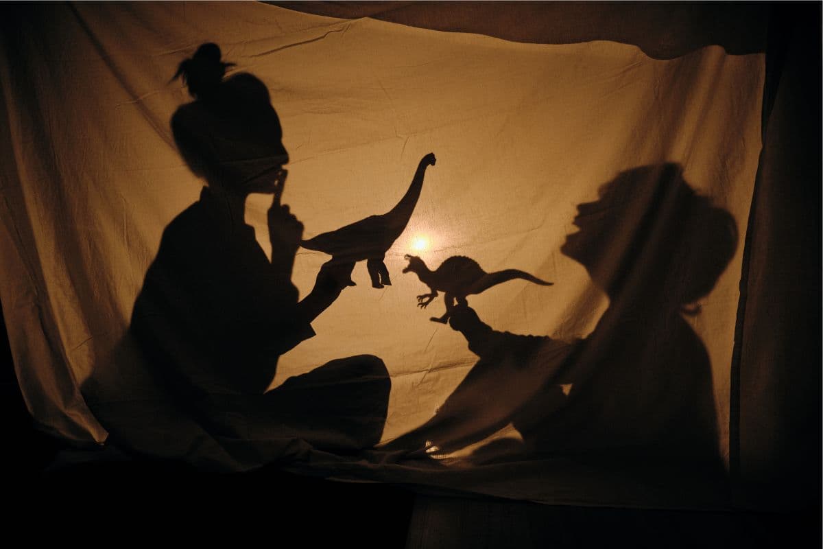mom and son playing in a tent with dinosaurs