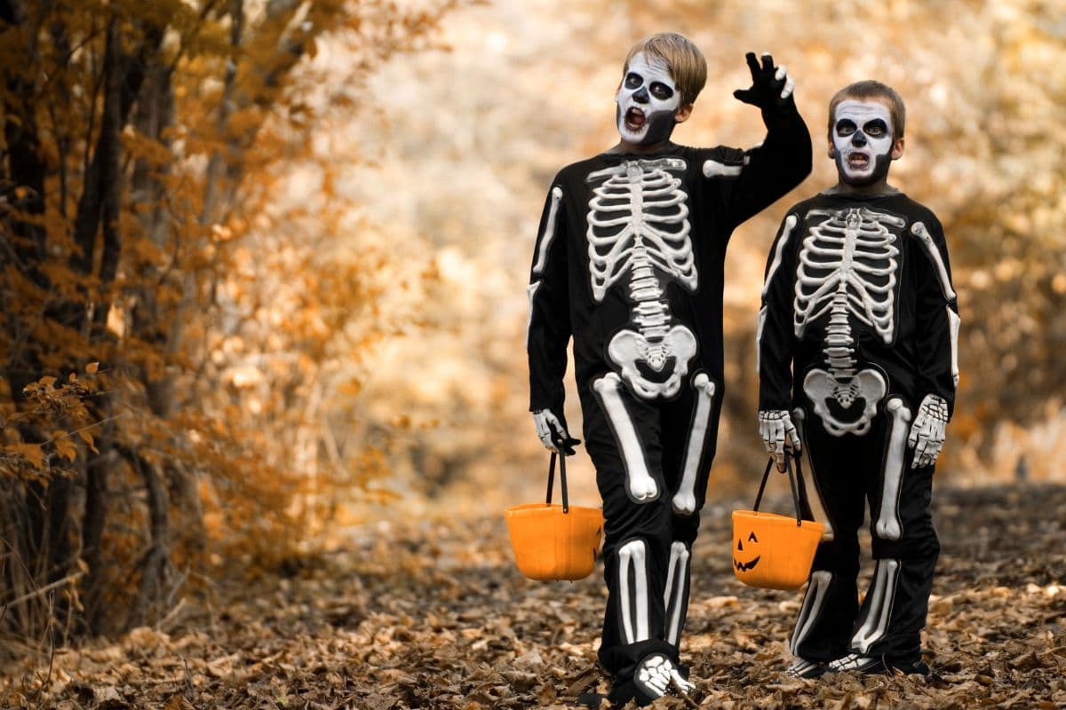 two kids dressed as skeleton and trick or treating
