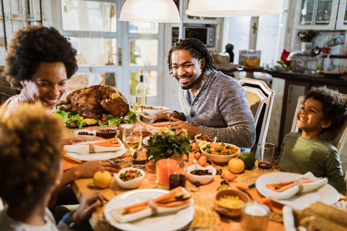 family laughing at Thanksgiving meal at table