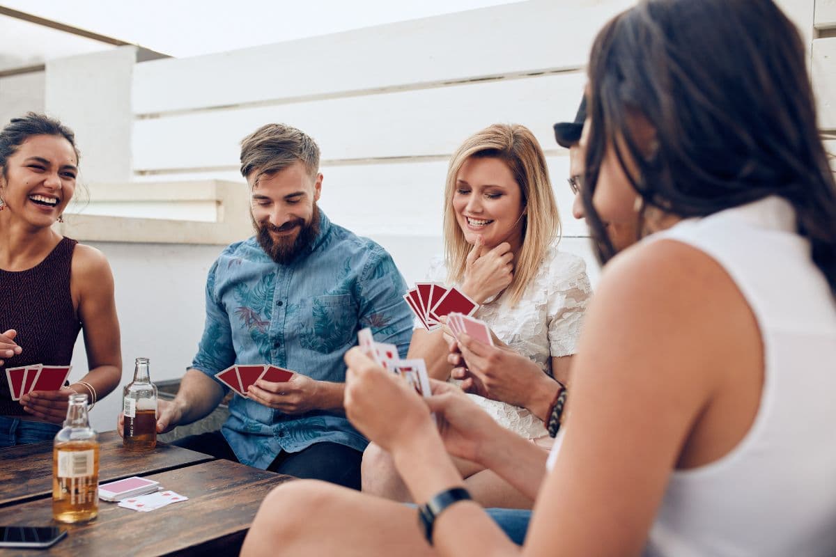 adults playing cards and drinking games