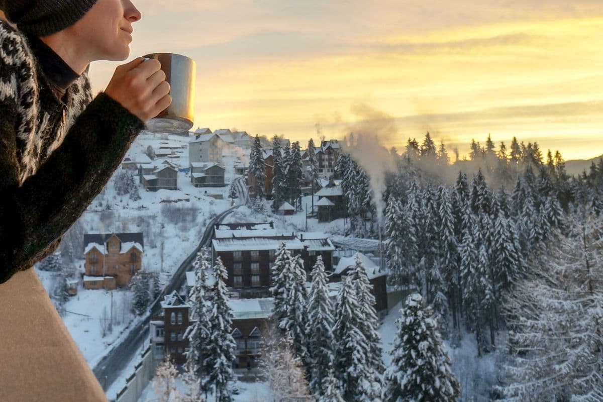 beautiful winter scene and person drinking a warm drink