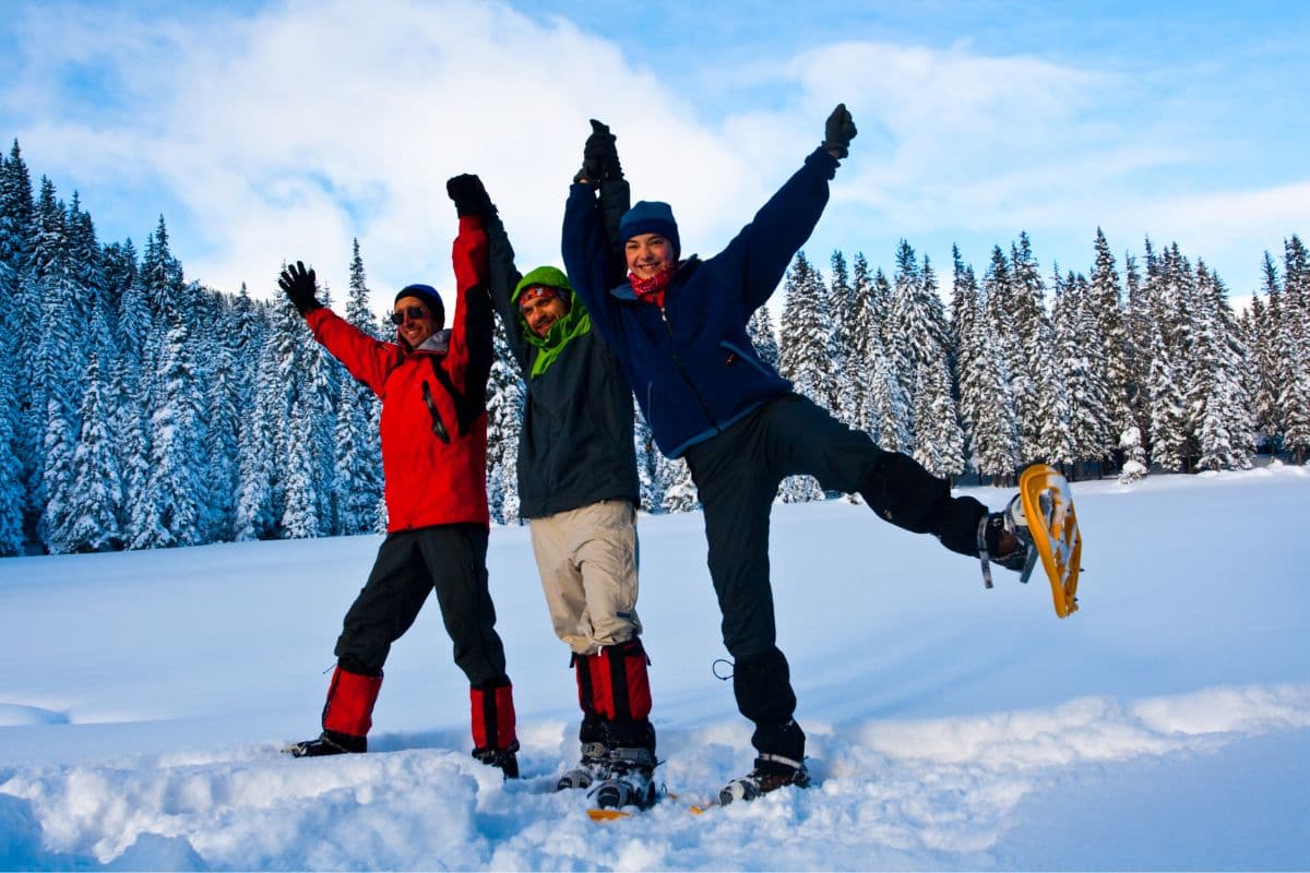 three people snowshoeing outdoors