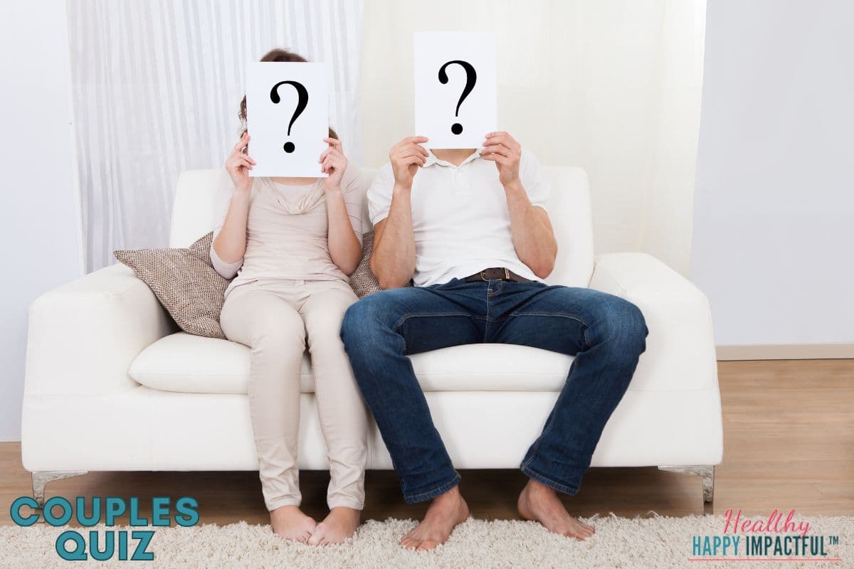 couple sitting on couch holding up question marks