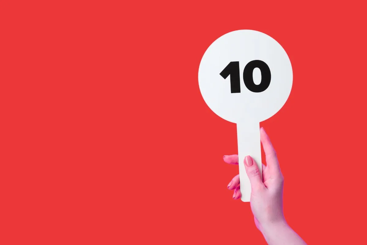 person holding up a paddle with the number 10